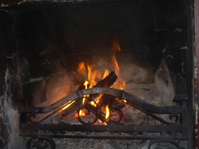 an old fire burning in a brick fireplace