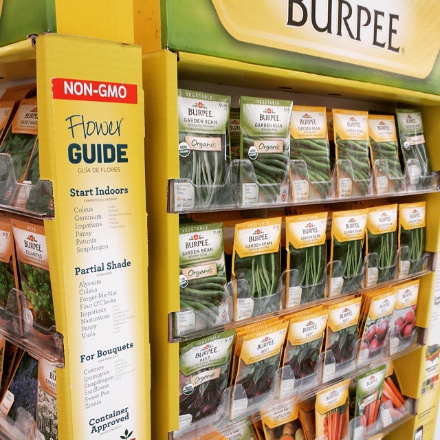 store display with seed packets containing carrots, onions and other vegetables