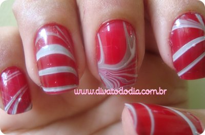 some red and white nail polish with a marble design