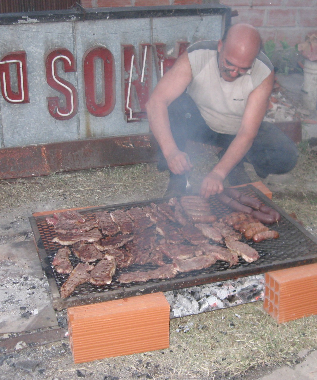 a man grilling chicken on an open grill