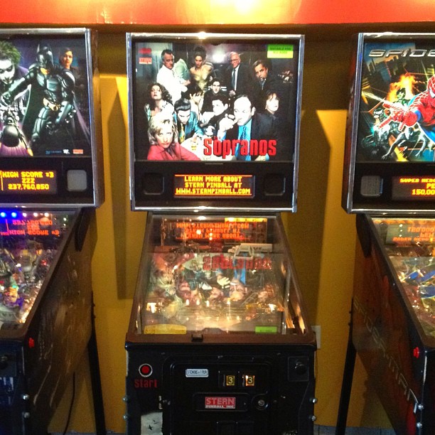 three arcade machines with one of the top players has multiple machines on each