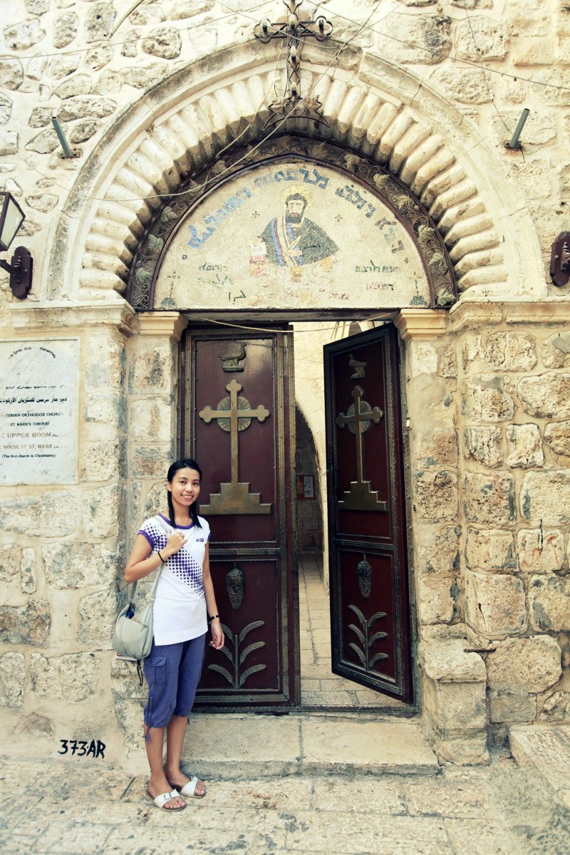 a woman is standing in front of the entrance to an old building