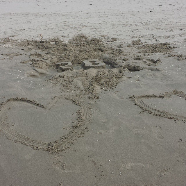 the heart shaped word love is written in the sand