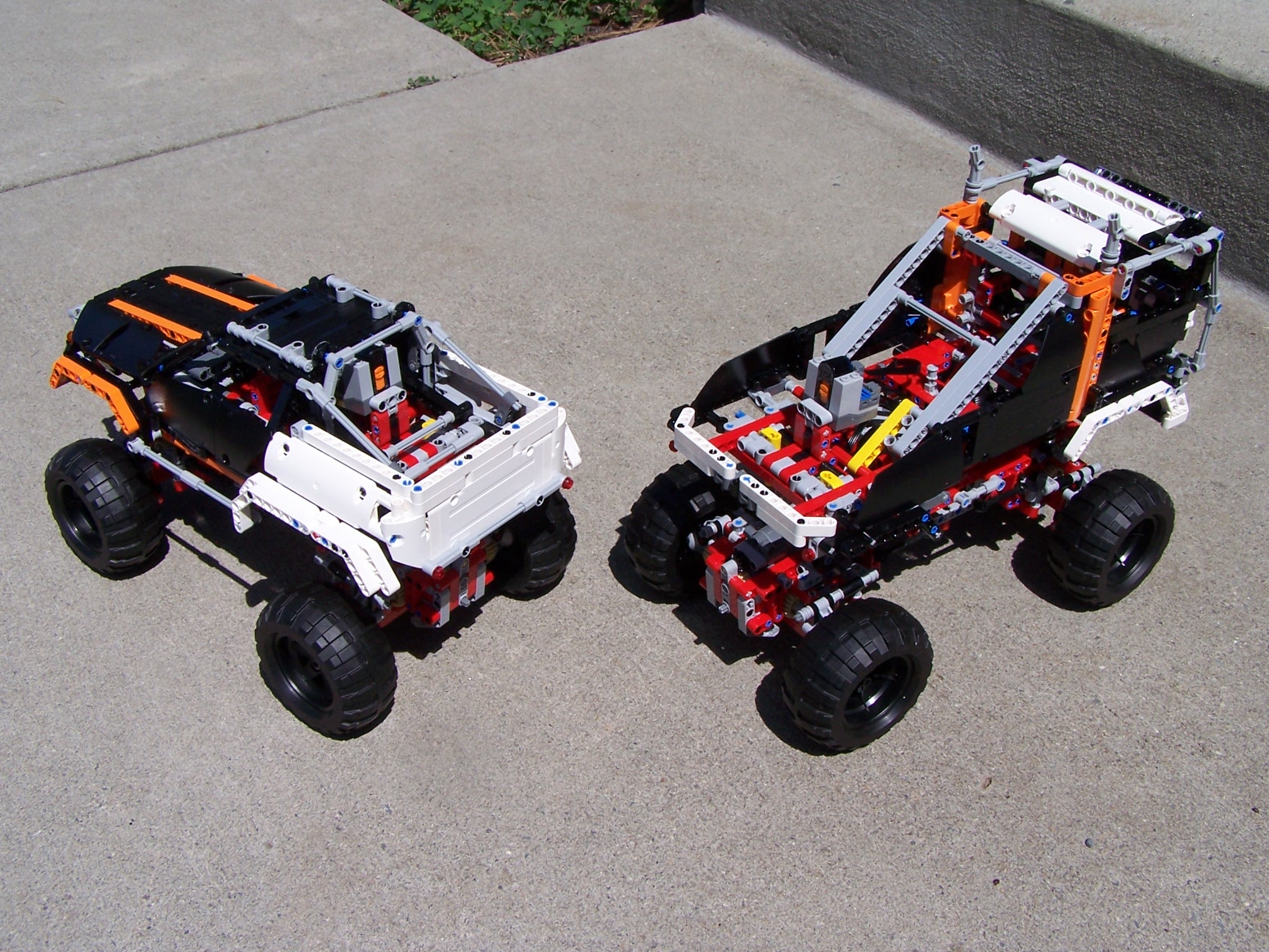 two toy trucks are side by side on the sidewalk