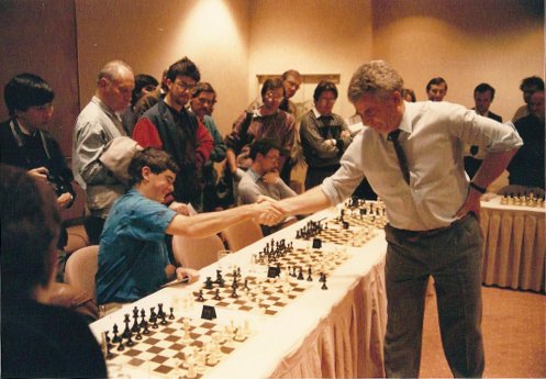 a man playing chess while others look on