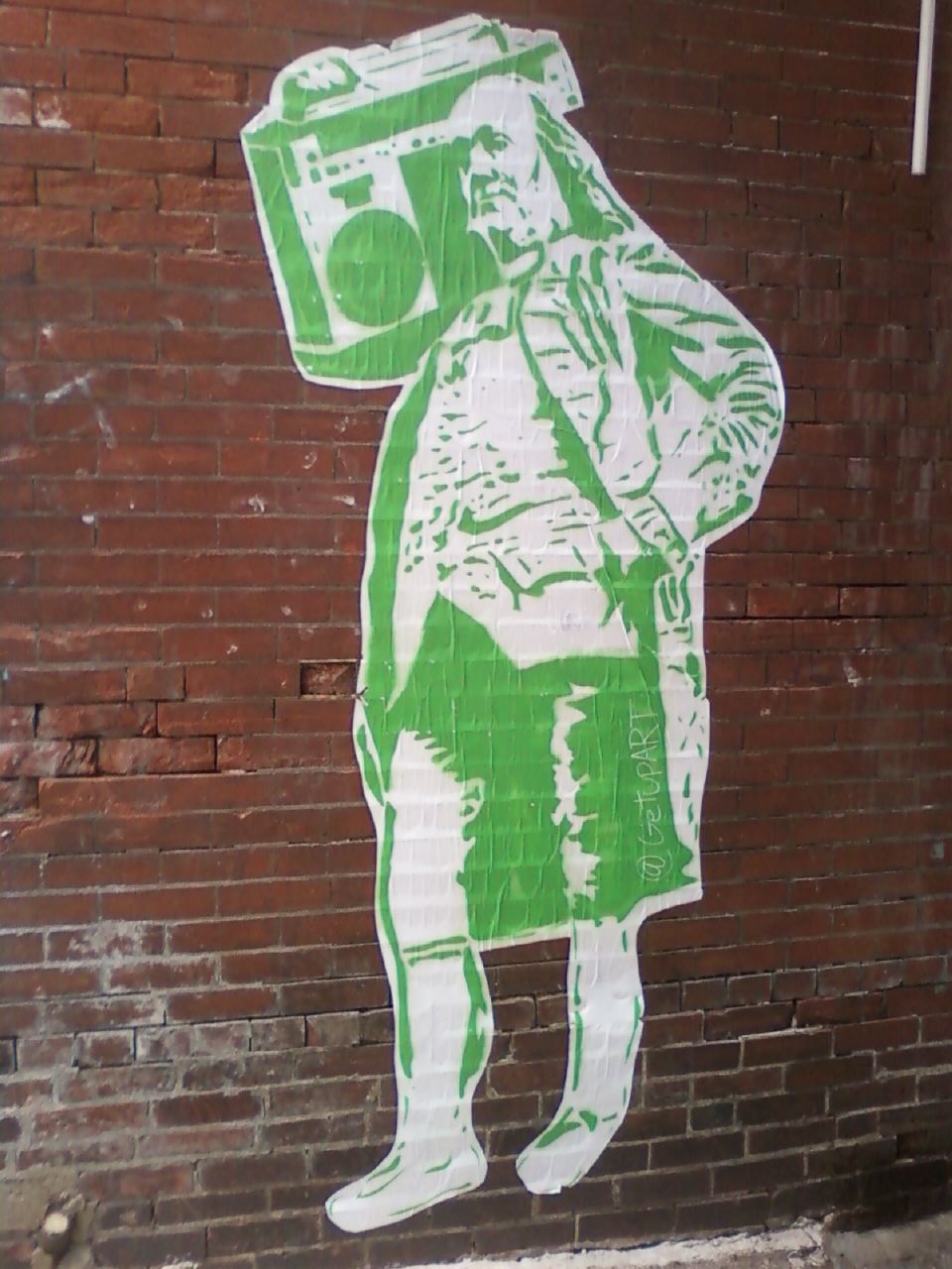 a large green advertit is painted on a brick wall