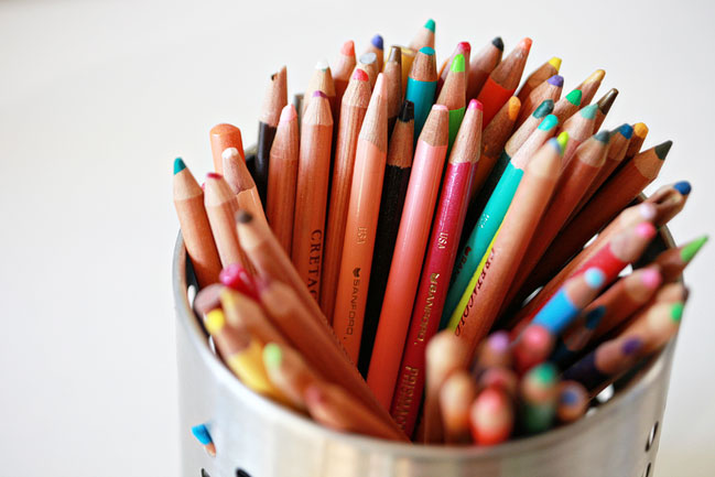 a cup full of pencils in front of a table