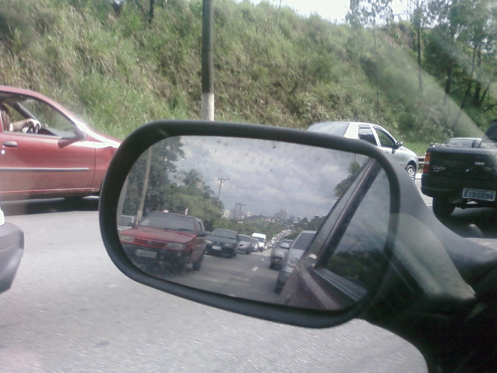 side view mirror of a car driving down the road