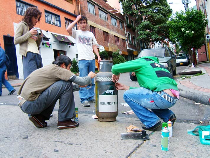 a group of people kneeling down with one man putting an empty fire hydrant in front of him
