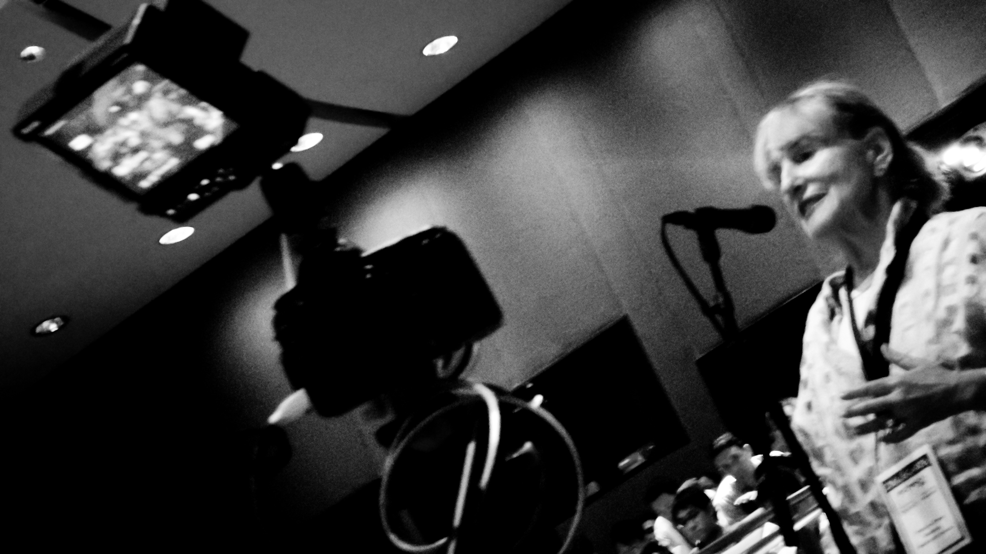 a woman in a kitchen cooking with a microphone