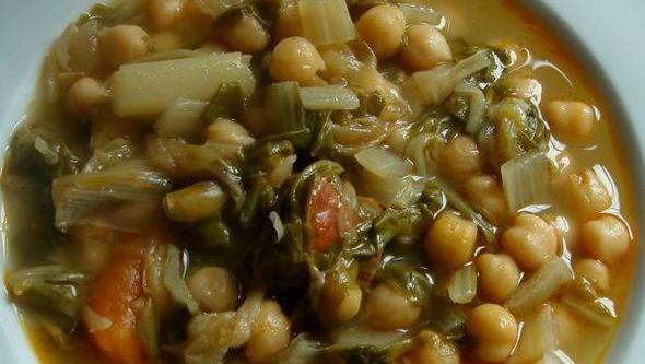 a plate of beans and veggies soup with onions
