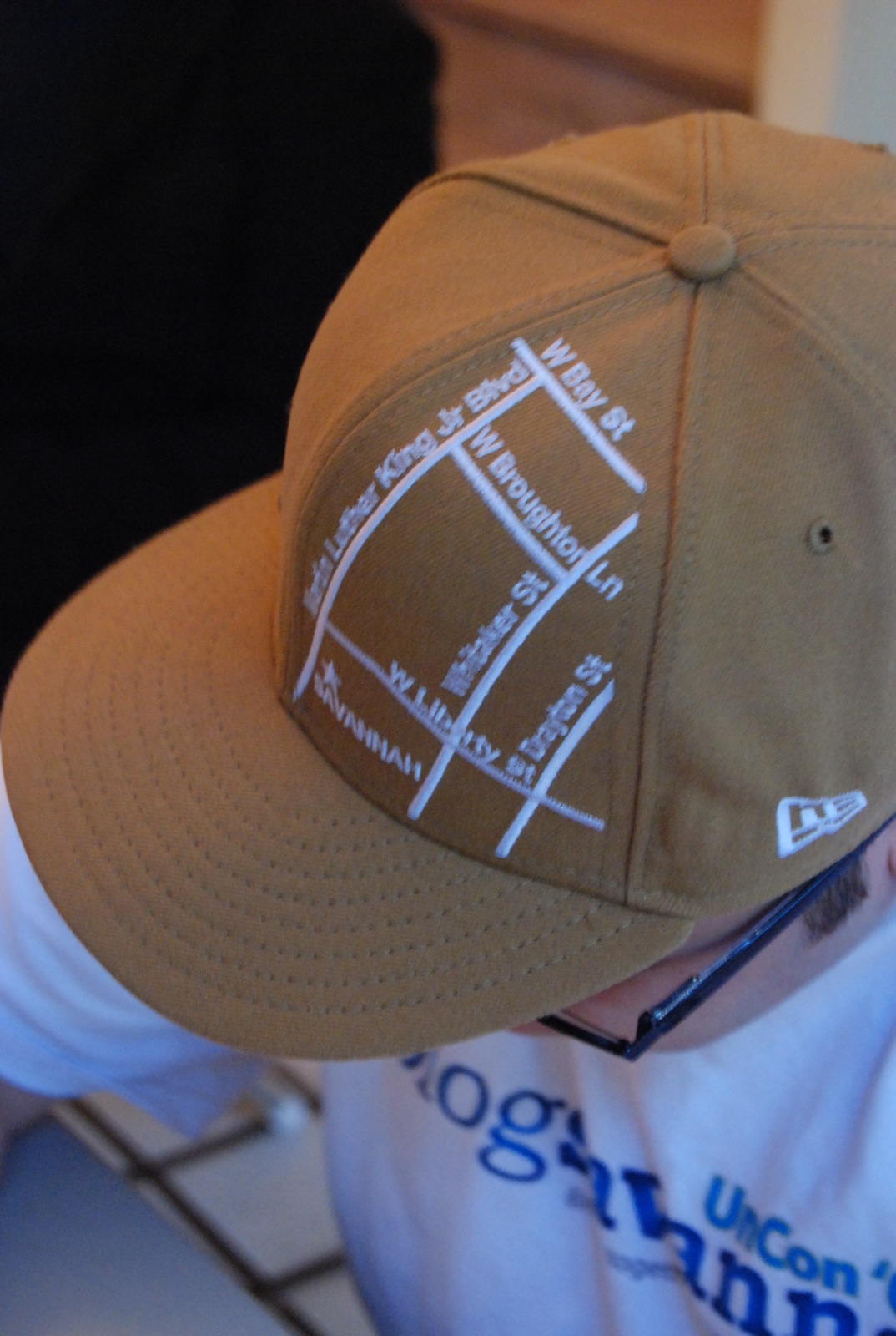 a brown baseball cap has a line of letters on it