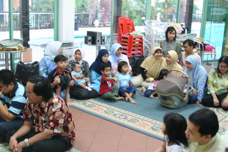 a large group of people sitting around each other on the floor