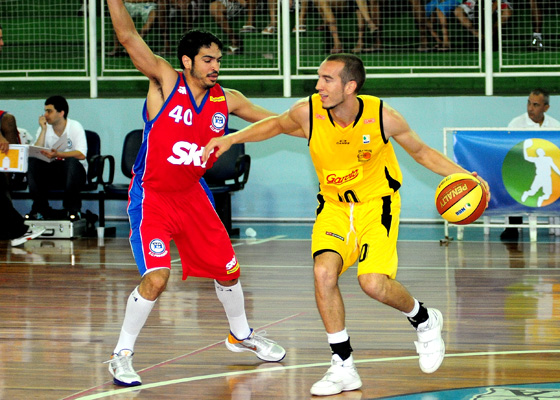 two basketball players are in the air trying to get control of the ball