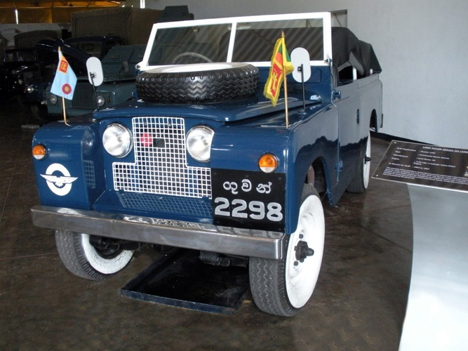 a jeep in a garage, on display, with flags