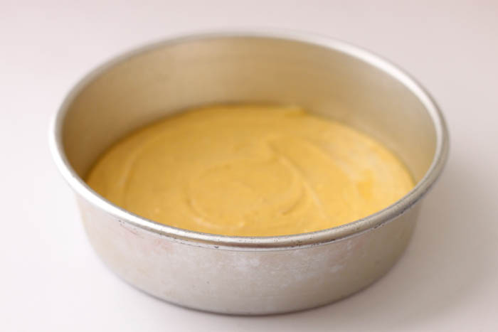 yellow batter in a metal tin with a white background