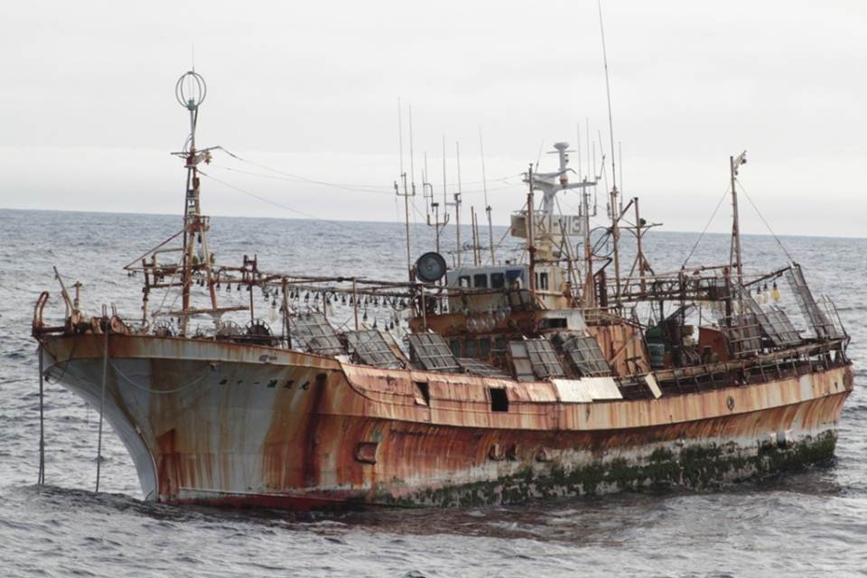 rusted out, derelict, old ship in water near shore