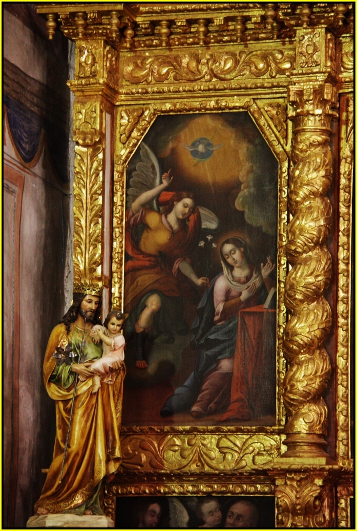 an ornate, gilded and gold wall hanging over a small child