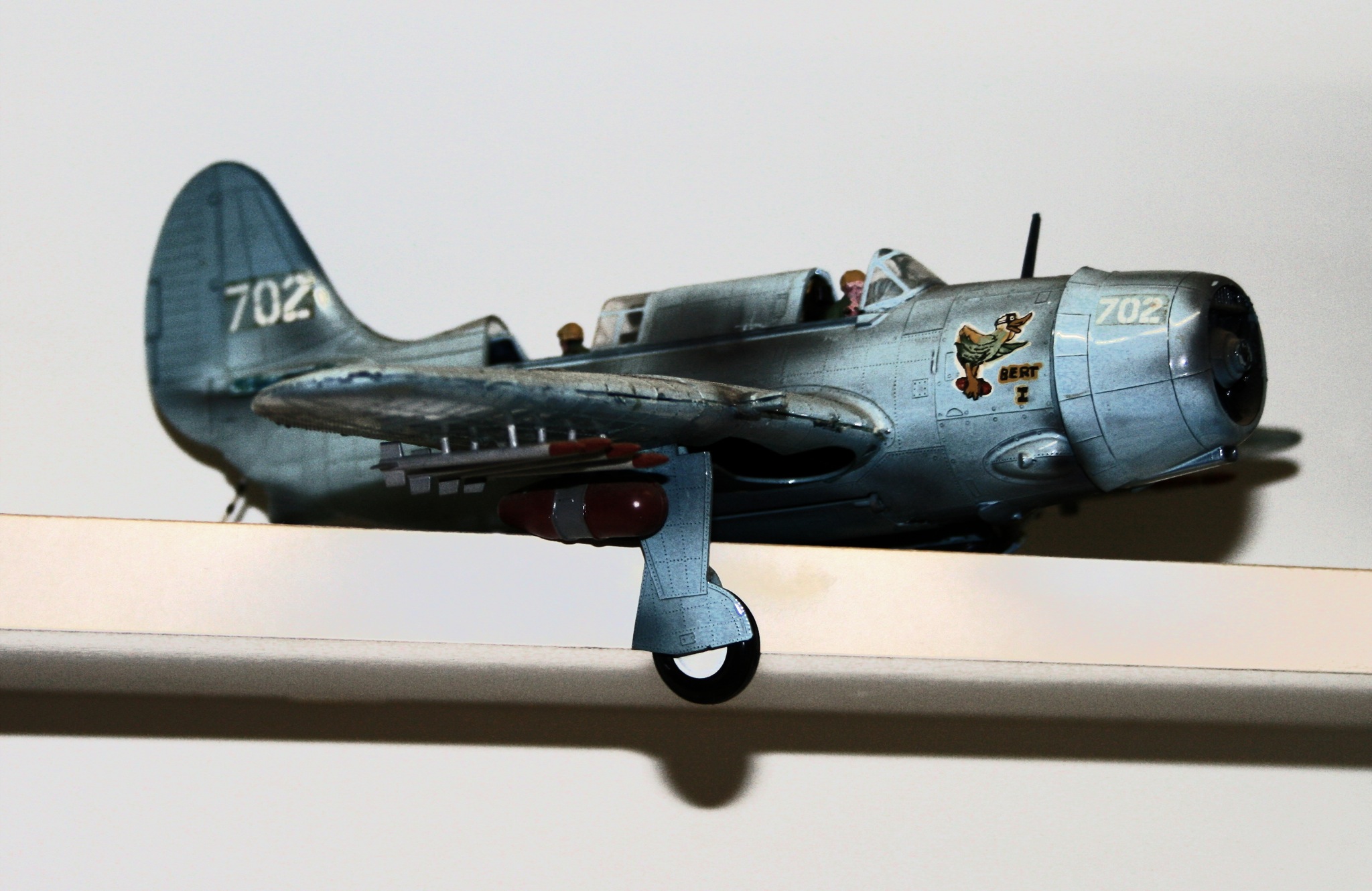 a toy airplane on a shelf with a wall in the background