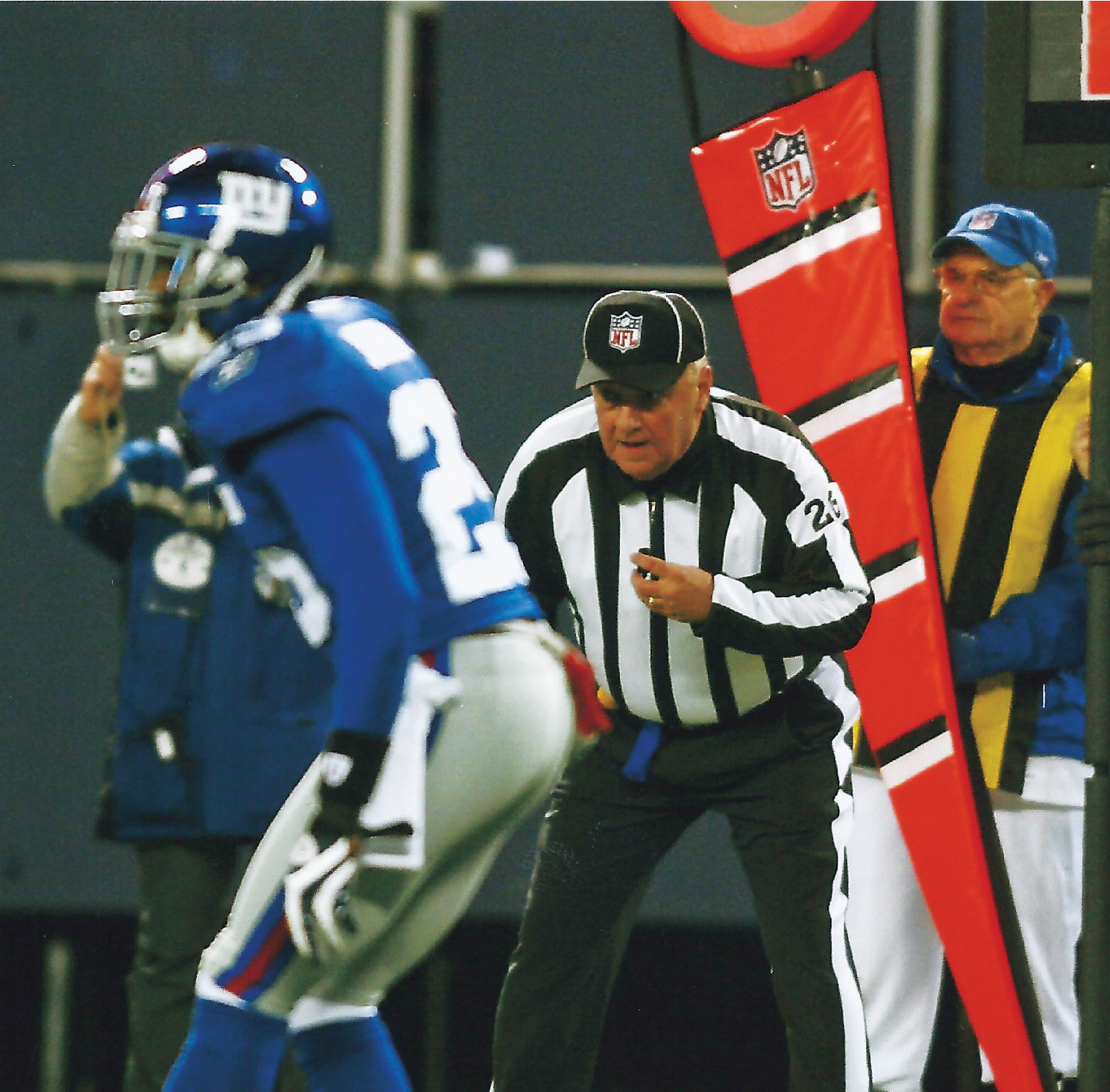 the referee watches as the football player gets ready for the snap