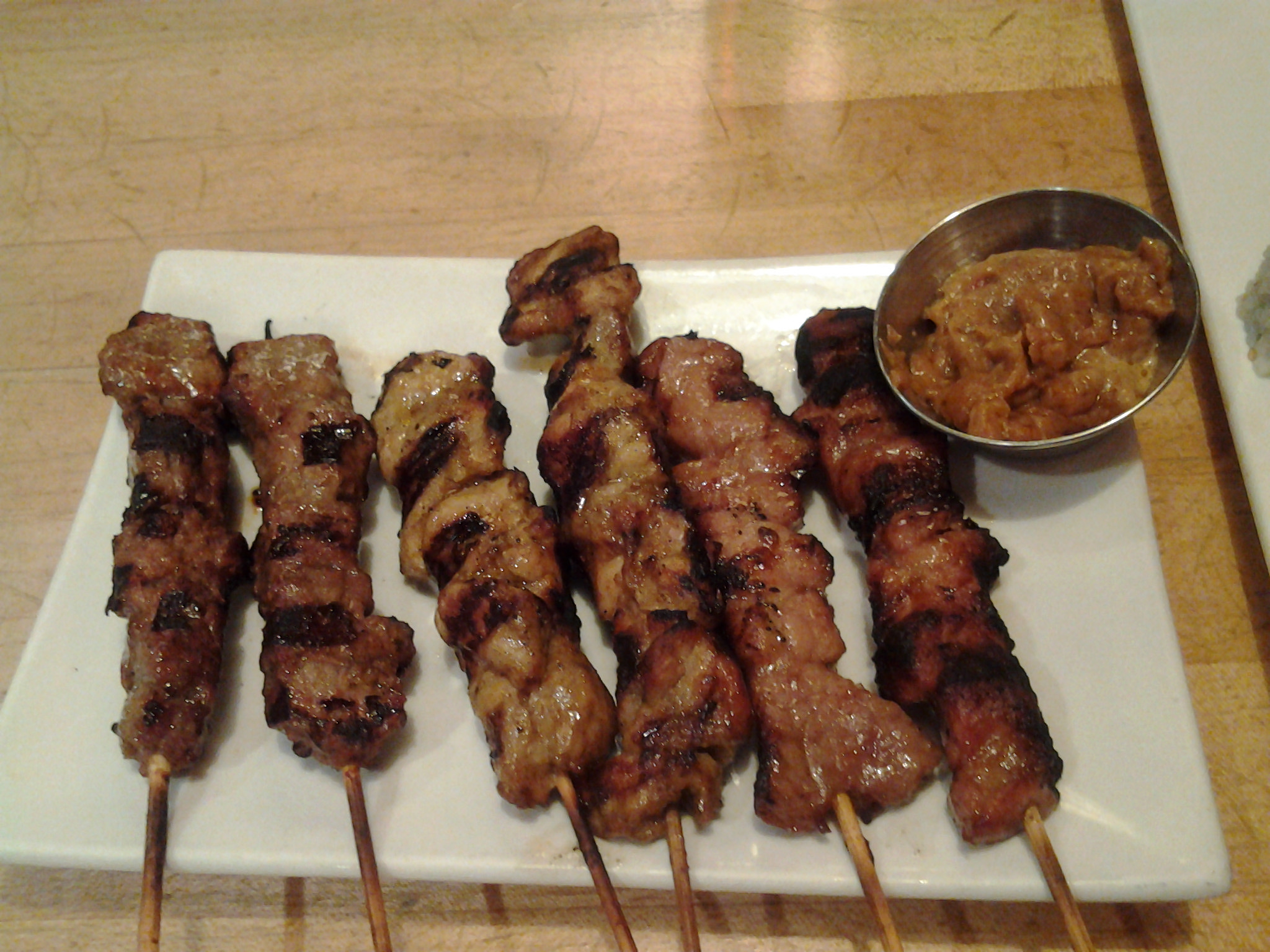 several shishkabe skewered to one another on a white plate