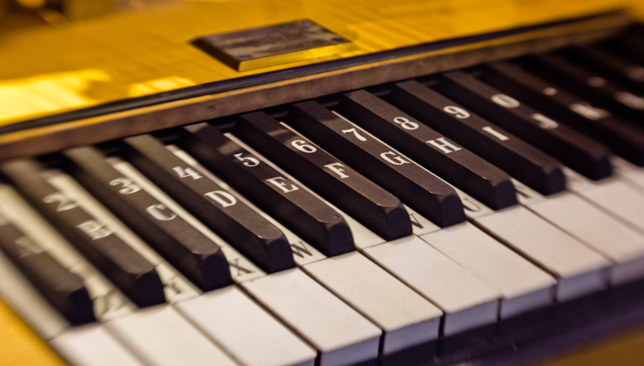 piano keys with black numbers sitting on a yellow surface