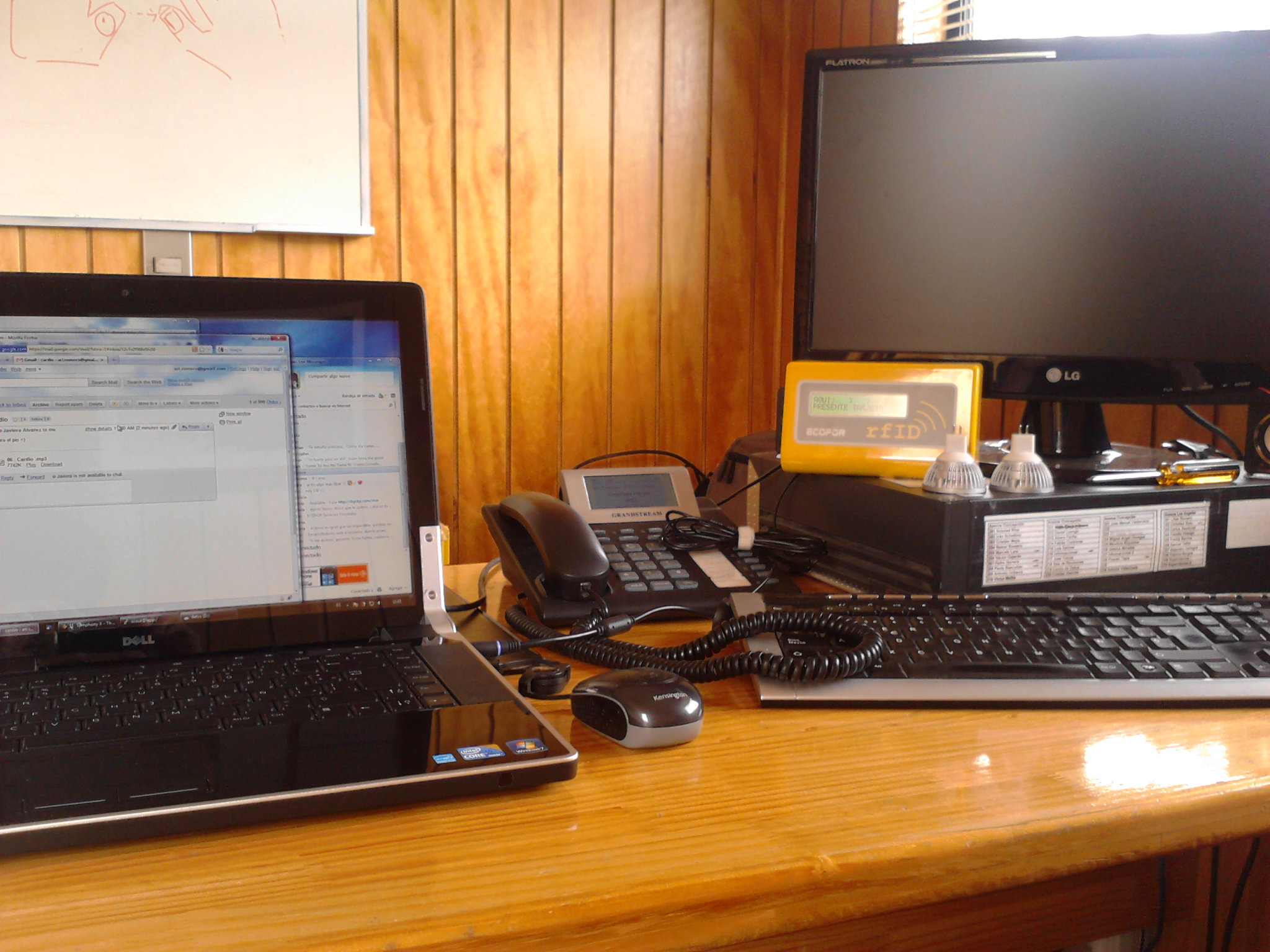 an office desk with a laptop, phone and two monitors