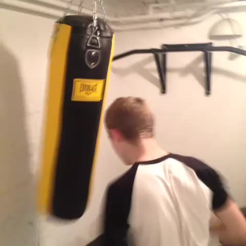 man wearing a black and yellow punching bag in front of his head