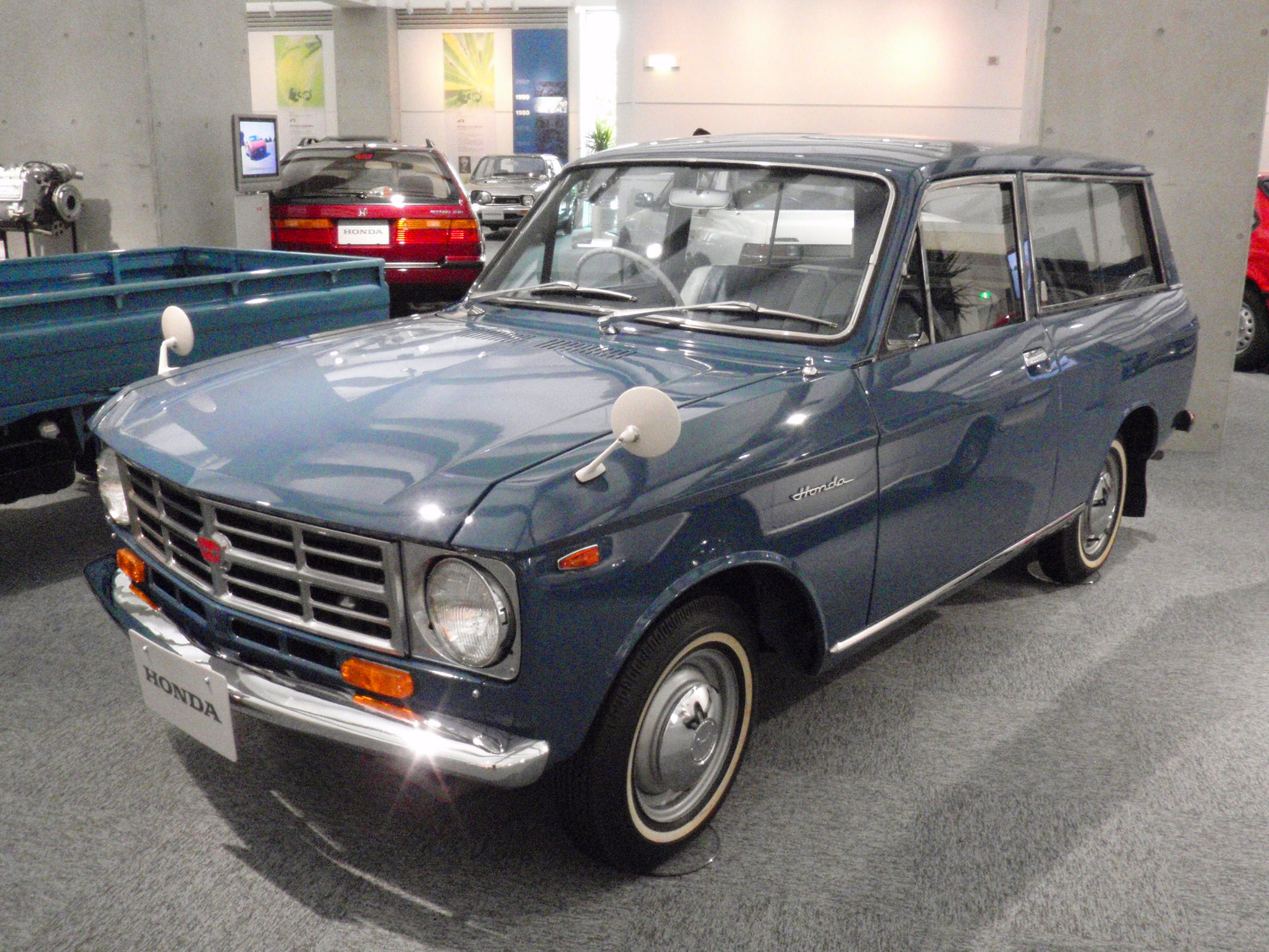 a small blue station wagon is on display