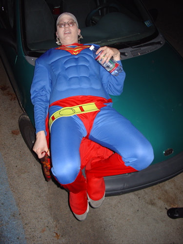 a man in superman costume sleeping in the bed of a car