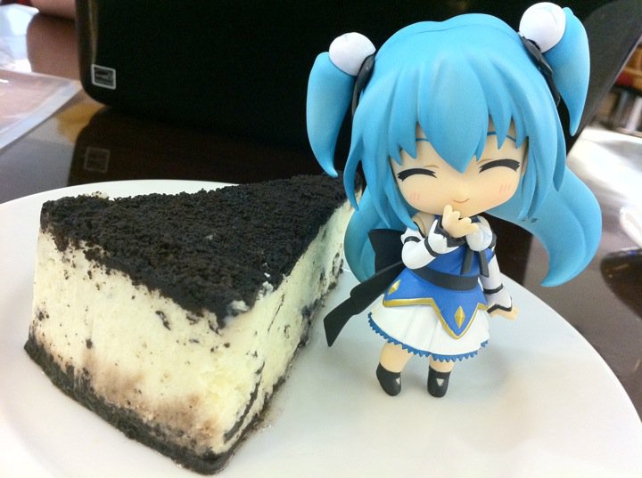 a white plate with a slice of cake and anime character