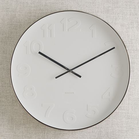 a wall clock with a black hands on a white surface