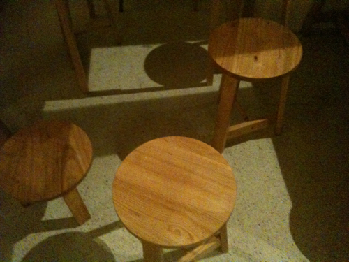 three wood stools, one in the middle and the other in the second