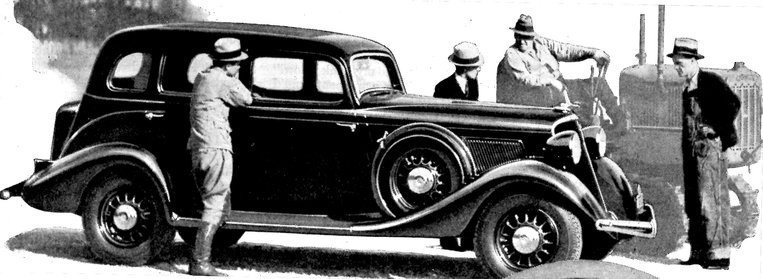 a man in a hat stands beside an antique car