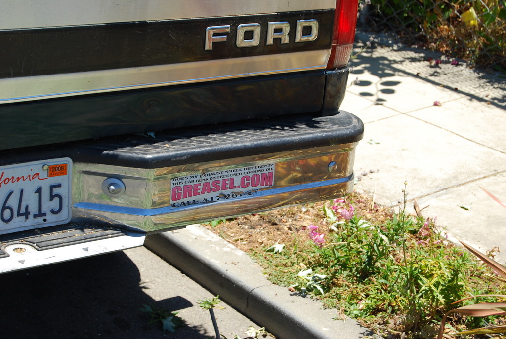 a license plate sitting next to the back of a car