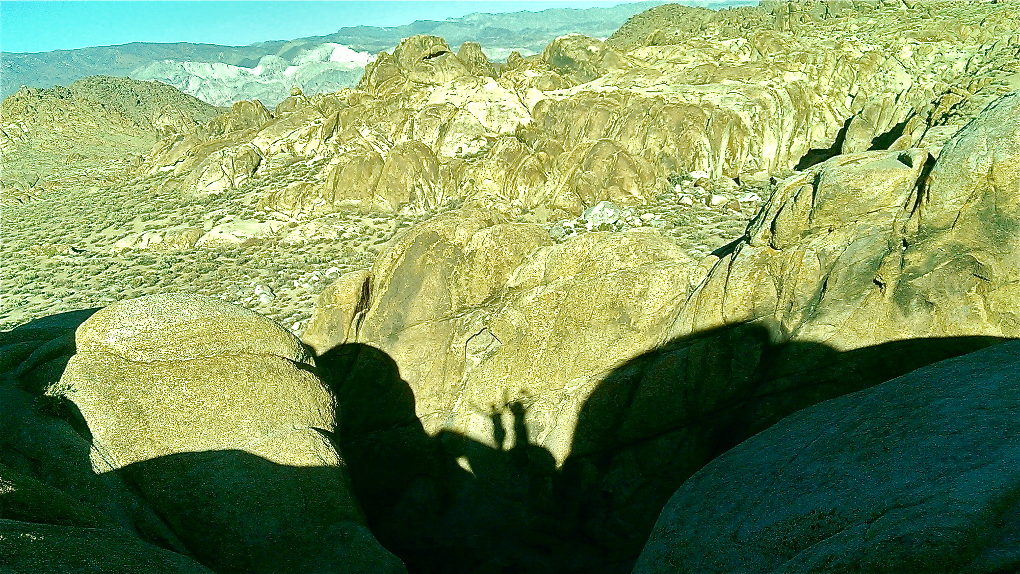 the shadow of a person on the top of a rocky mountain