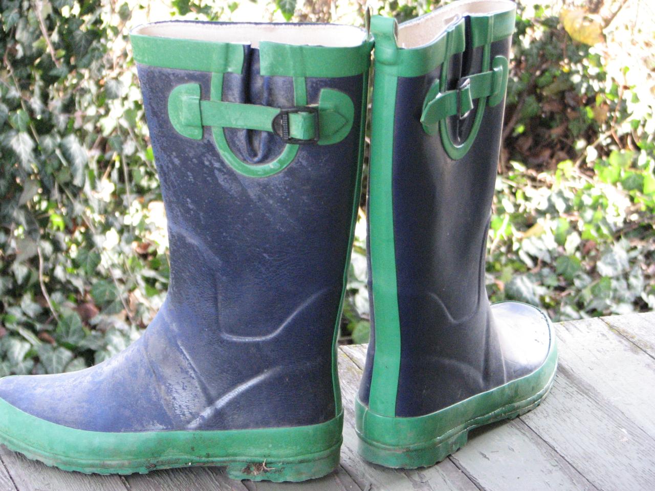 green and gray boots sitting on top of a wooden deck