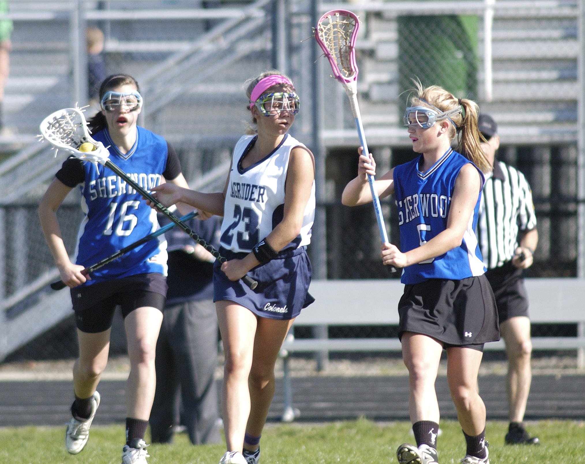 a group of girls playing a game of lacrosse