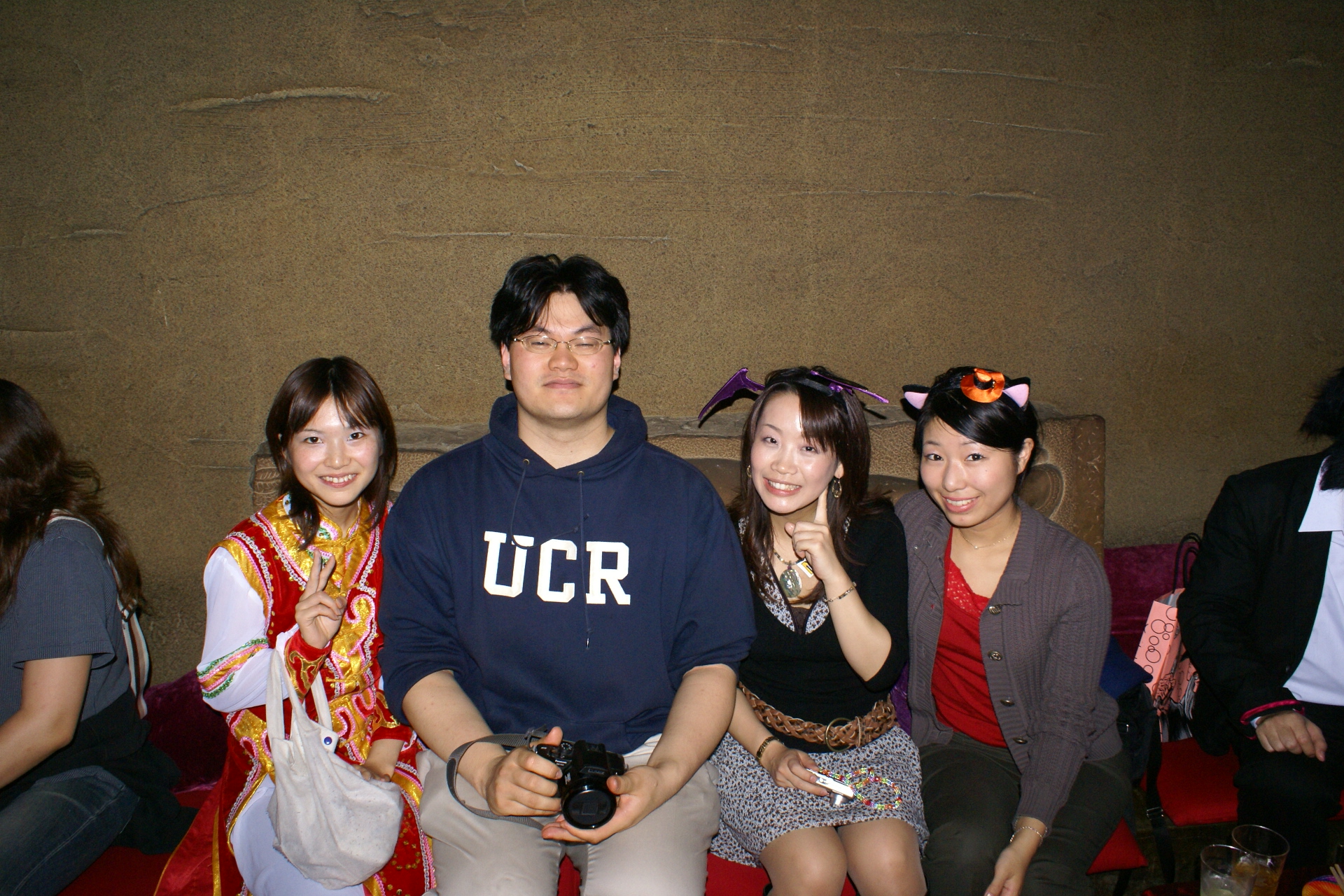 four people in front of a wall, one woman, and the other man