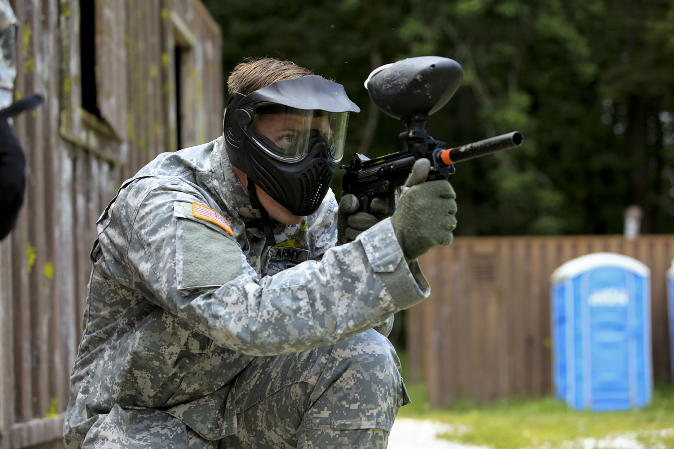 military man dressed in camouflage holding a paintball