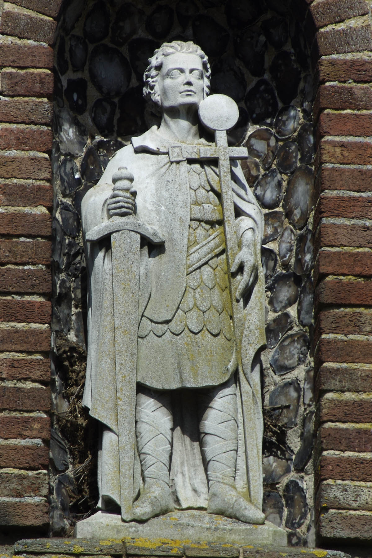 a statue of a man with a hat and cape on