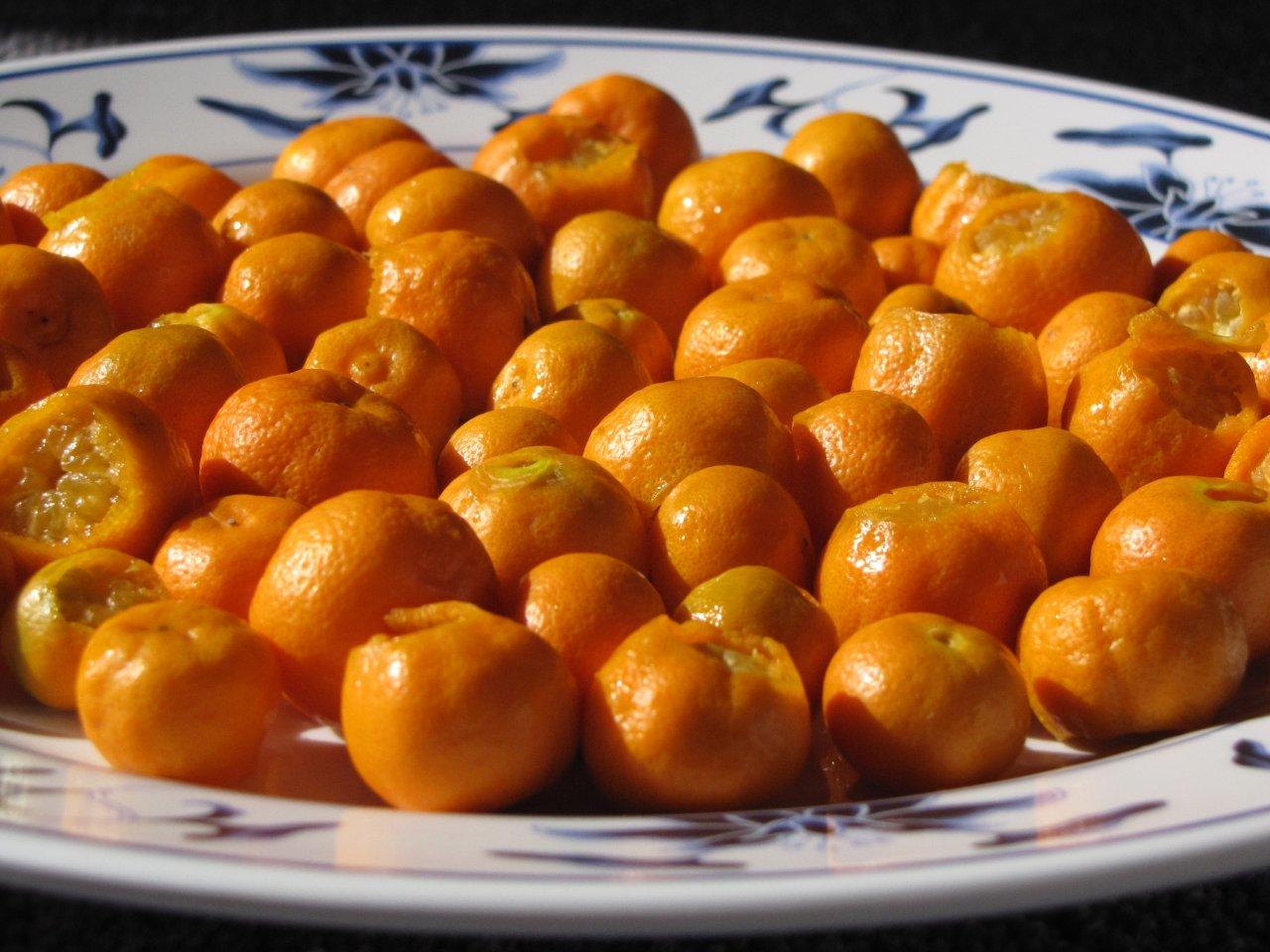 many oranges are on a plate with floral designs