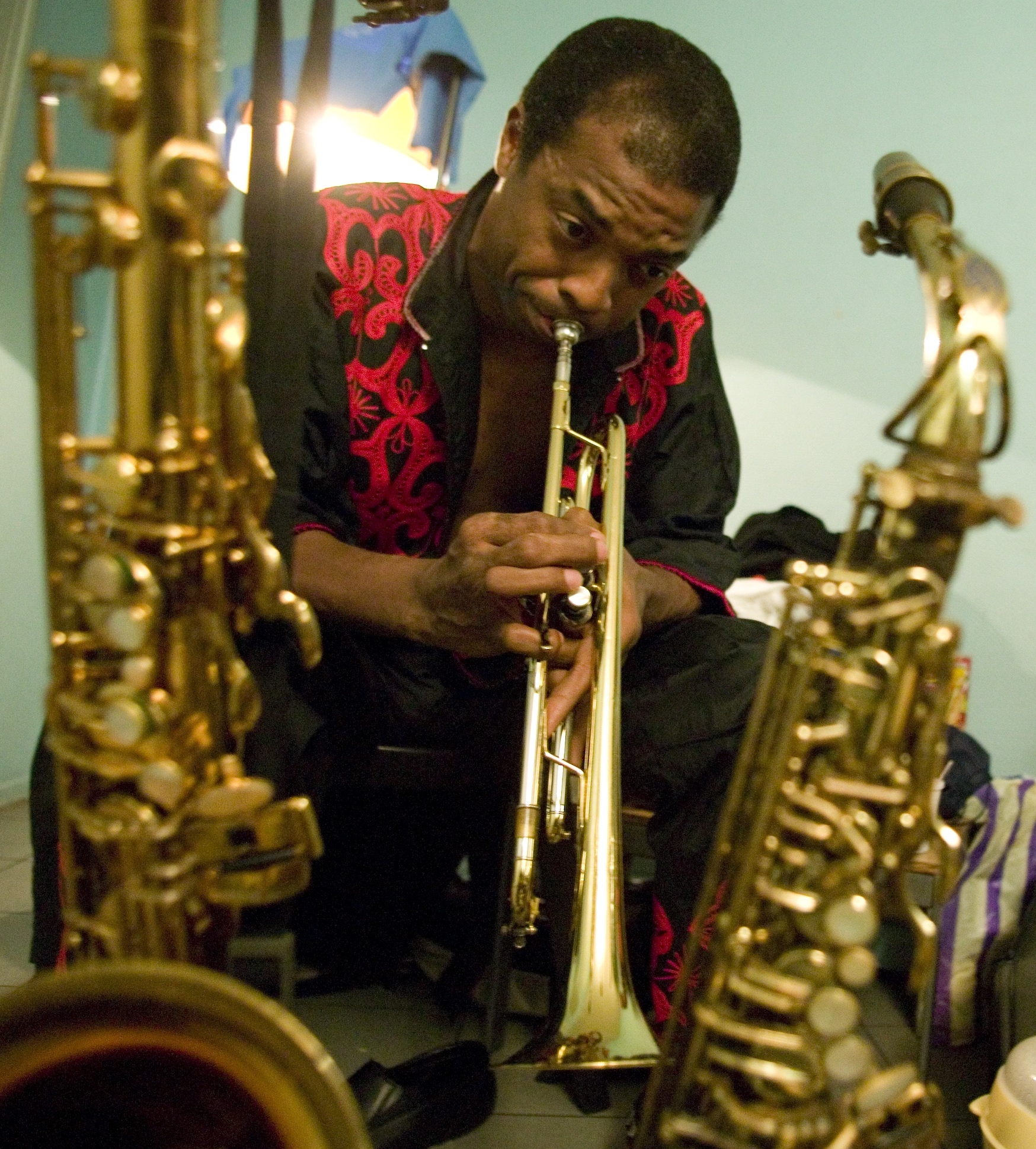 a man is playing his trumpet while he sits in the foreground