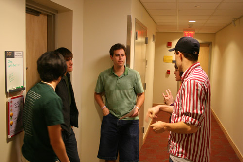 some young men in a hallway talking to each other