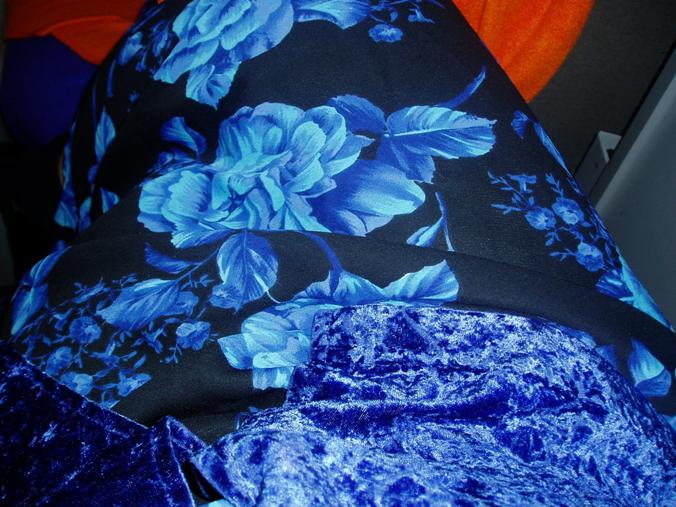 a blue flower print couch sitting on top of a bed