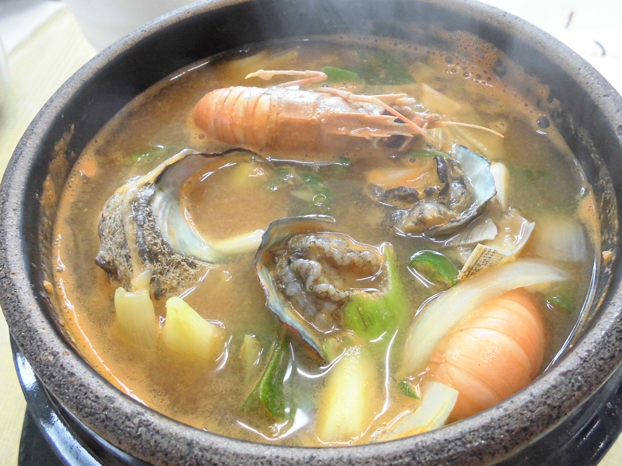 a pot full of soup sitting on top of a stove