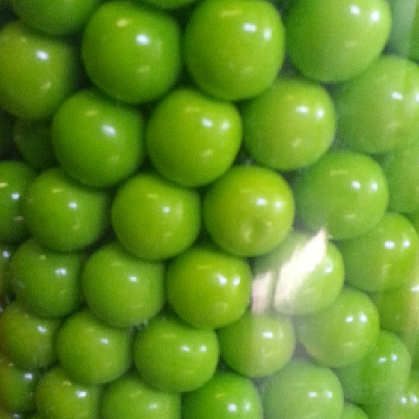 a close up of many green fruits in a white container