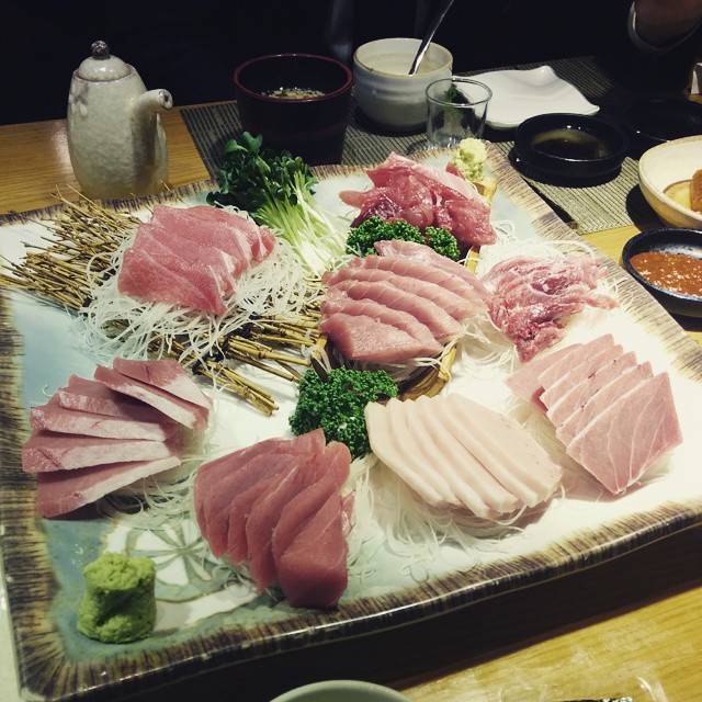 a wooden table topped with a plate of sushi