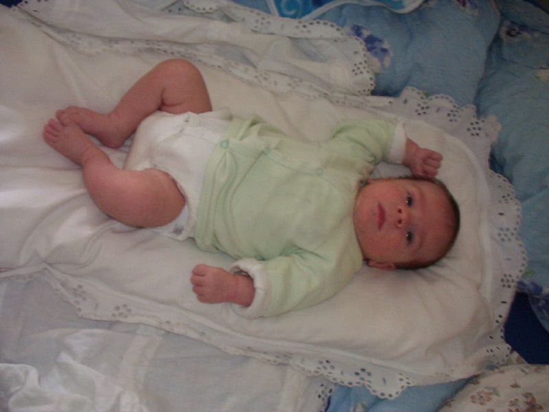 a baby laying on a blanket with white trim