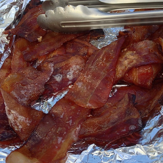 a knife, fork and chopped bacon sitting on a foil wrapper